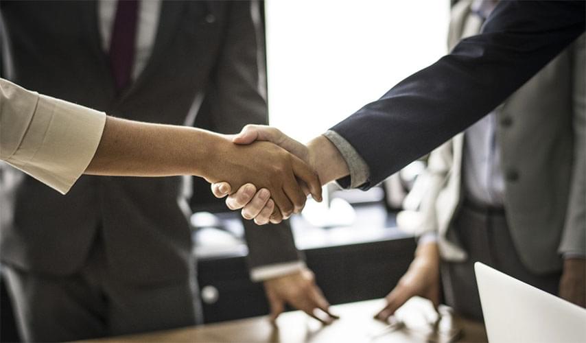 Two professionals shaking hands over a new deal.